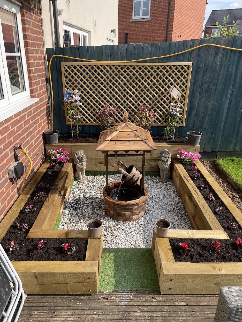 A landscaped garden completed by E&D, with raised beds, flowers and a central seating area